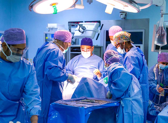 A team of surgeons performing an operation under surgical lights