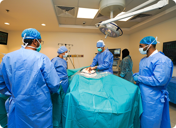 A team of surgeons performing an operation under surgical lights